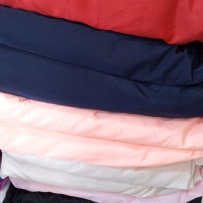 Premium suit lining fabric in multiple colors neatly folded for tailoring, suits, blazers, and fashion design