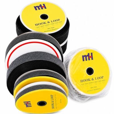 Black hook and loop fastening tape rolls on yellow spools for tailoring, garment making, fashion accessories, shoe making, upholstery, and DIY crafts.