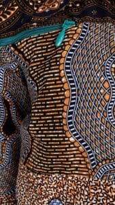 Close-up of a premium teal nylon coil zipper sewn into Ankara fabric, ideal for dresses, skirts, bags, cushions, and professional tailoring projects.